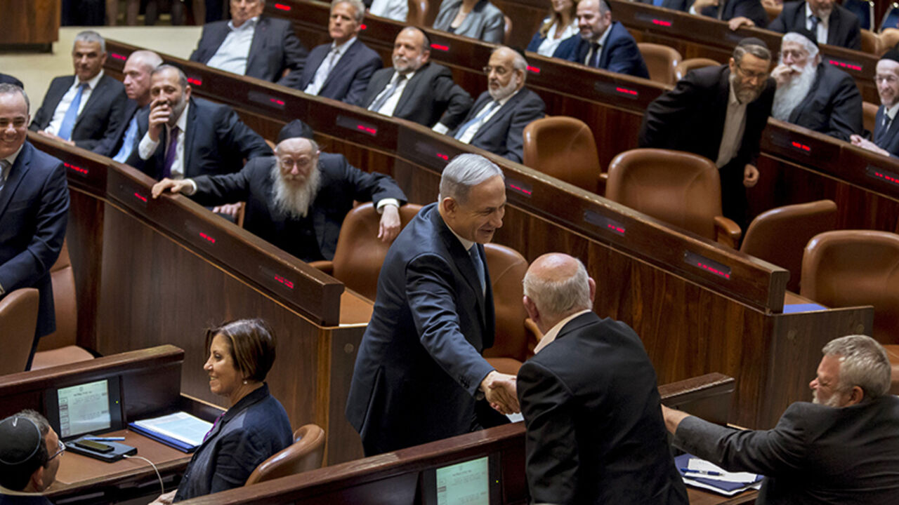 ISRAEL-POLITICS/ Israeli Prime Minister Benjamin Netanyahu (C) shakes hands with members of the opposition after he was sworn-in as Prime Minister for the fourth time, to lead the 34th Israeli government, at the Knesset, the Israeli parliament, in Jerusalem May 14, 2015. Netanyahu's new rightist coalition government, hobbled from the outset by its razor-thin parliamentary majority, was sworn in late on Thursday amid wrangling within his Likud party over cabinet posts. Picture taken May 14, 2015. REUETRS/Jim Hollander/Pool -