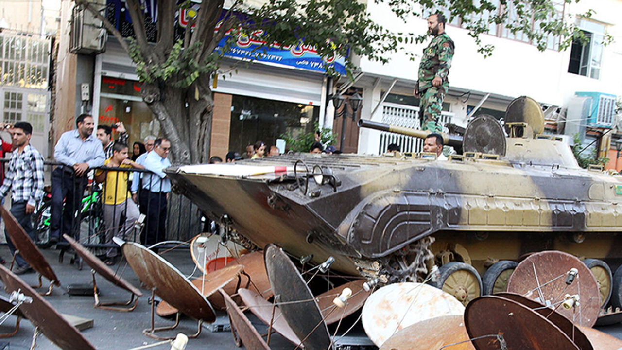Nic6251305 A picture taken on September 28, 2013 and obtained from Iran's ISNA news agency shows Iranian soldiers destroying satellite dishes with an army tank in a street of the southwestern city of Shiraz. The Iranian authorities carry out regular crackdowns to seize satellite dishes, removing them from rooftops, and issue warnings against their use. AFP PHOTO/ ISNA/MOHSEN TAVARO (Photo credit should read MOHSEN TAVARO/AFP/Getty Images)