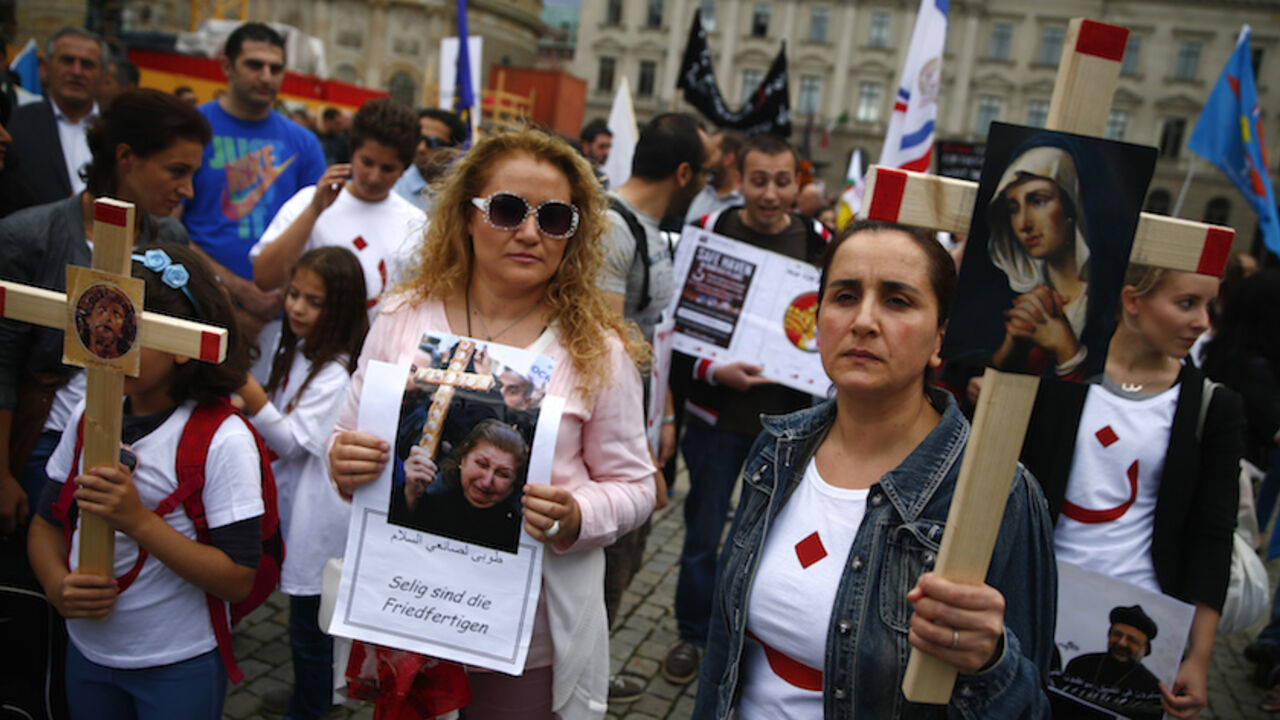 IRAQ-SECURITY/ People hold crosses during a rally organised by Iraqi Christians living in Germany denouncing what they say is repression by the Islamic State militant group against Christians living in Iraq, in Berlin, August 17, 2014. REUTERS/Thomas Peter (GERMANY - Tags: POLITICS RELIGION CIVIL UNREST) - RTR42QAF