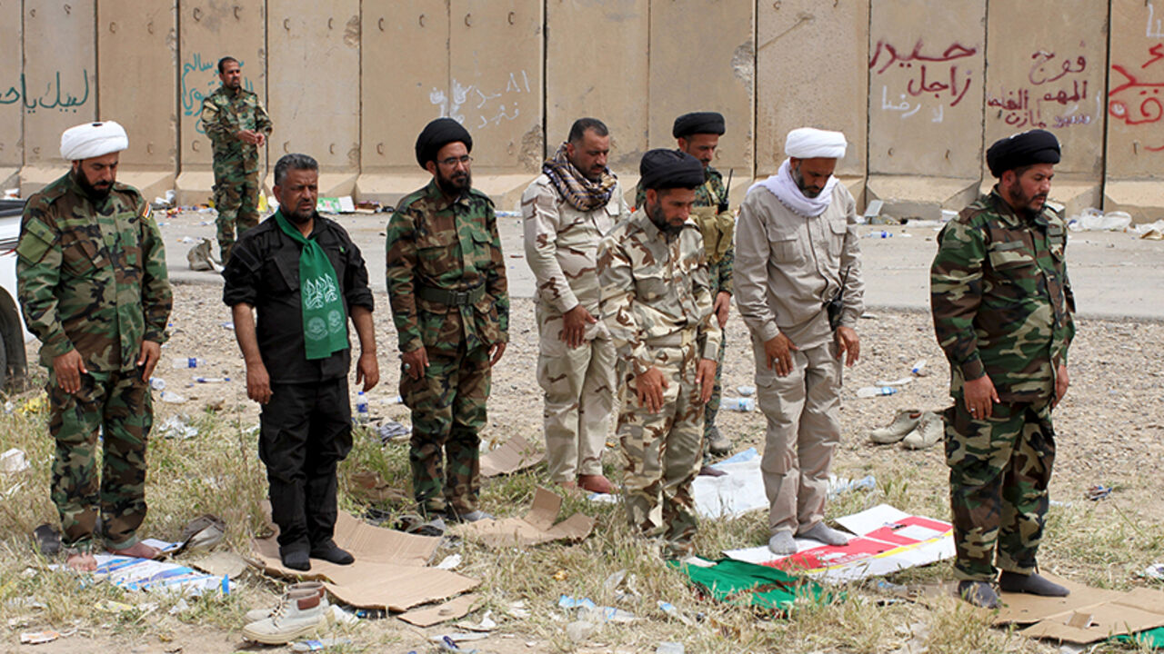 MIDEAST-CRISIS/IRAQ-TIKRIT Shiite clerics from Hashid Shaabi (Popular Mobilisation) forces, allied with Iraqi forces against the Islamic State, pray in Tikrit March 28, 2015. Four Iraqi soldiers were killed in street fighting with Islamic State militants in Tikrit overnight as they advanced slowly into the city, a Sunni jihadist bastion, in the wake of coalition air strikes, a security official said. REUTERS/Thaier Al-Sudani - RTR4V9FA