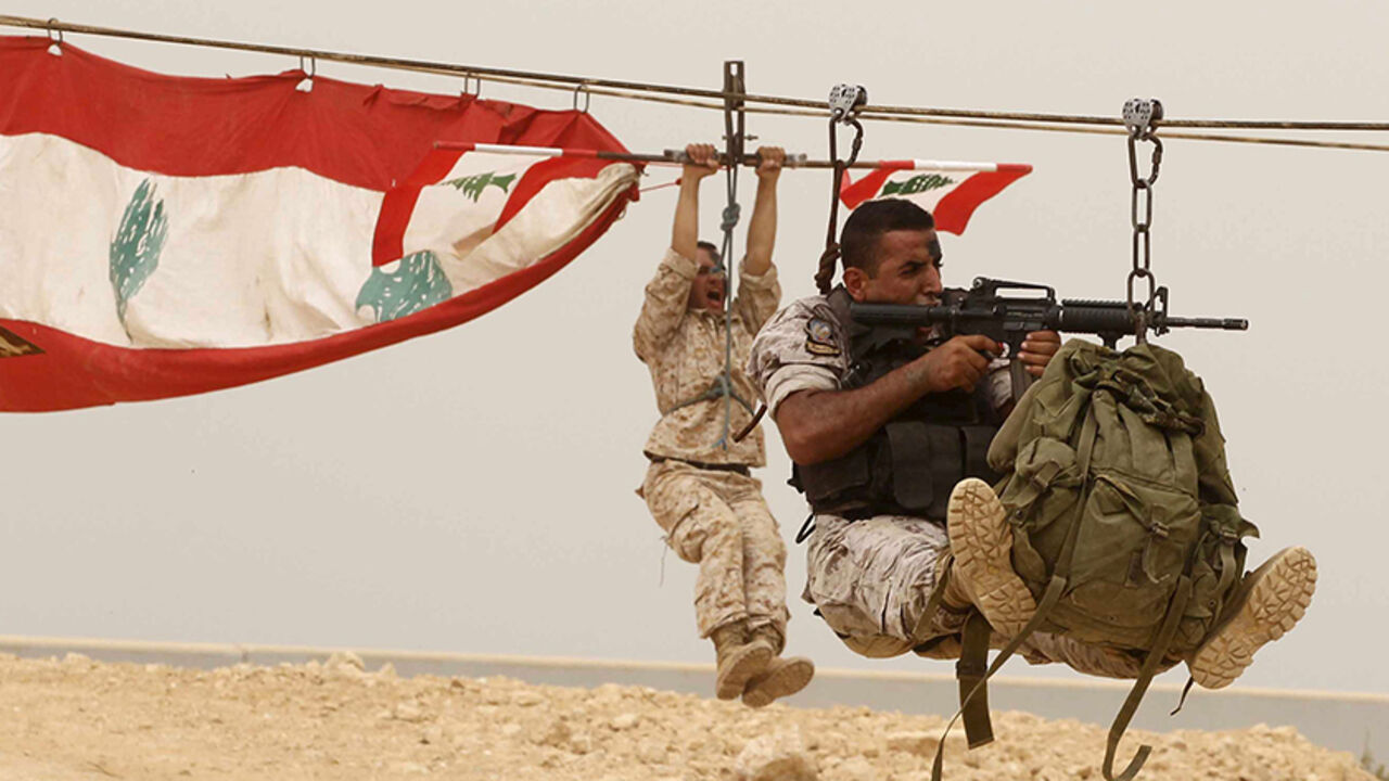 LEBANON-MILITARY/ Members of the Lebanese Army's airborne regiment perform a live drill, held as part of a weapons exhibition during the Security Middle East Show in Beirut, as a sandstorm engulfed Lebanon for a second day September 9, 2015. REUTERS/Mohamed Azakir - RTSBDO