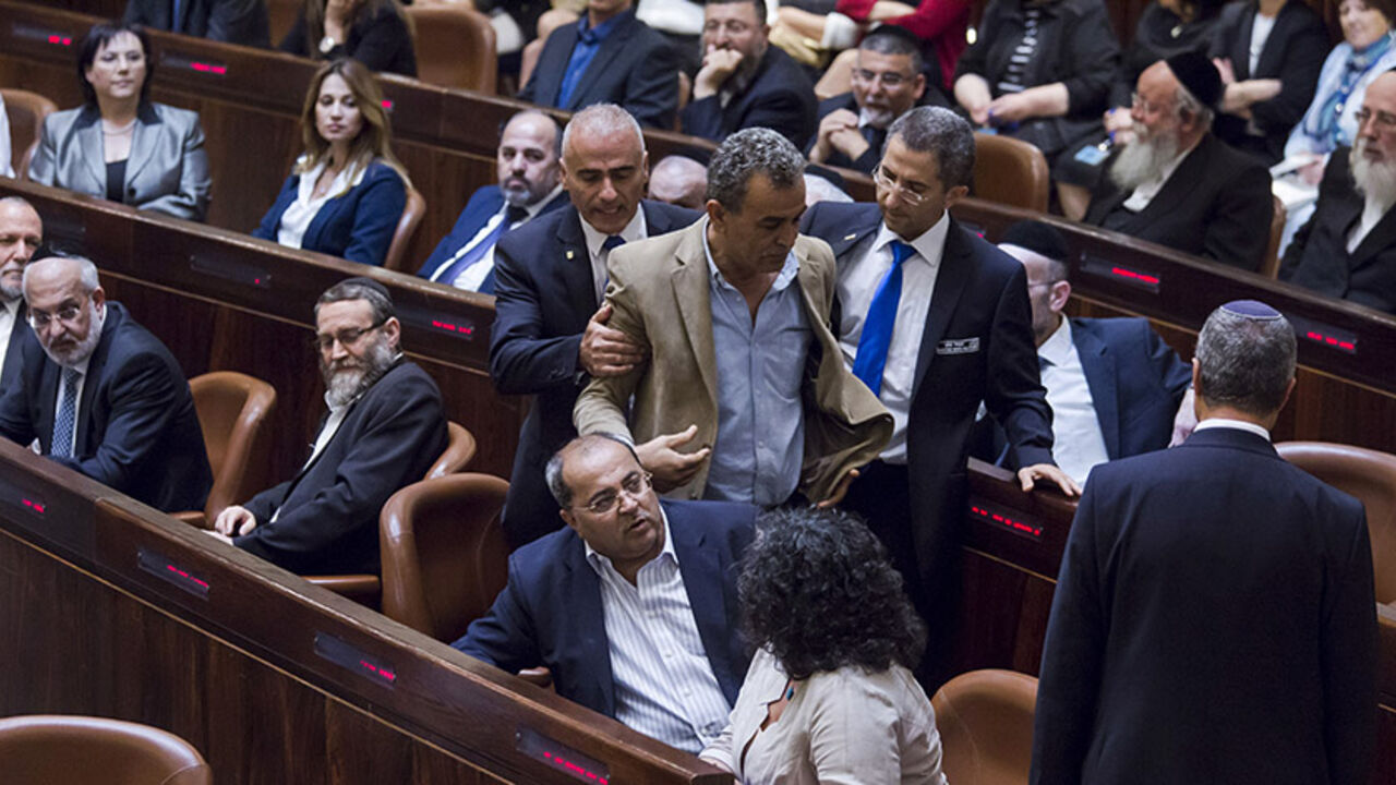 ISRAEL-POLITICS Jamal Zahalka (C), an Israeli-Arab lawmaker from the Joint Arab List, is taken out of the Knesset, the Israeli parliament, during Israeli Prime Minister Benjamin Netanyahu's speech as he presents his new coalition government following the mid-March general elections, in Jerusalem May 14, 2015. Netanyahu's new rightist coalition government, hobbled from the outset by its razor-thin parliamentary majority, was sworn in late on Thursday amid wrangling within his Likud party over cabinet posts. REUETRS/Jim Holl