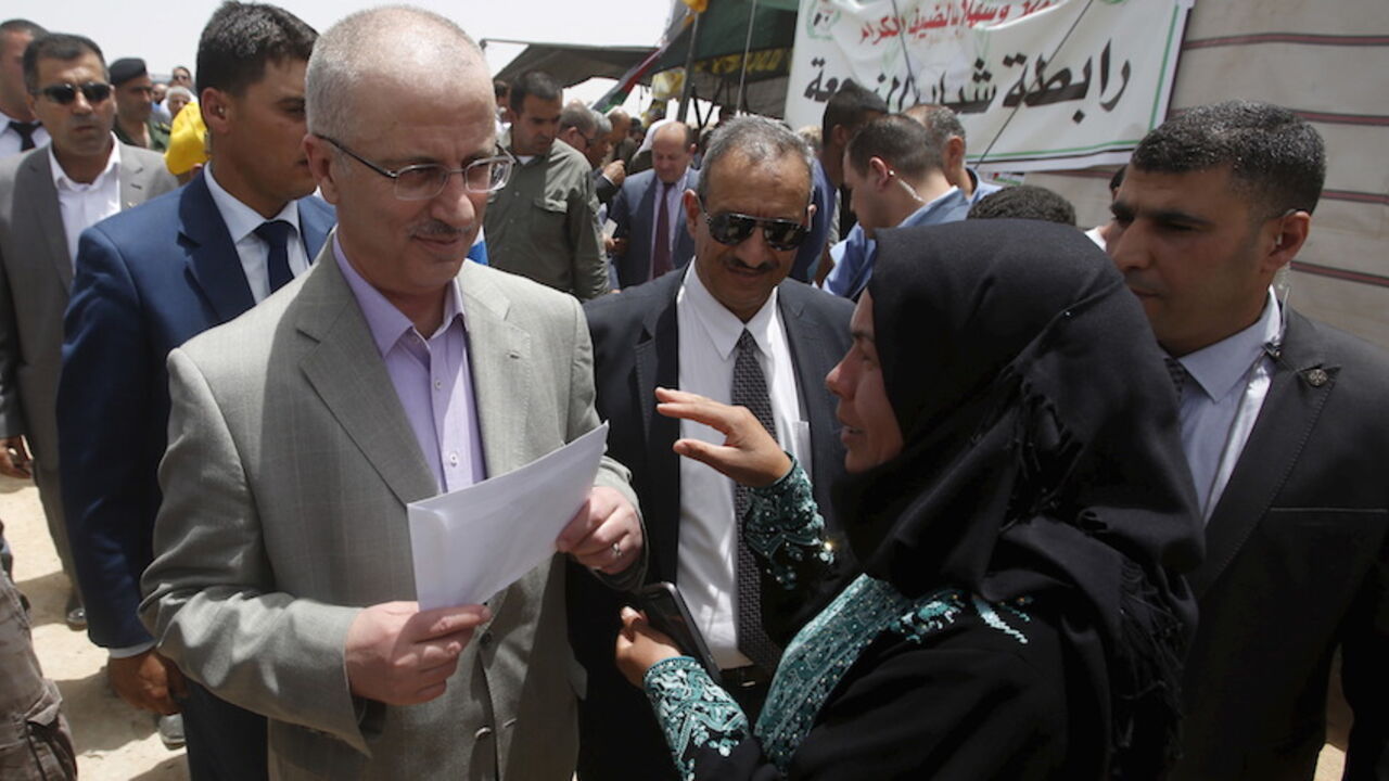 ISRAEL-PALESTINIANS/ A Palestinian woman talks to Palestinian Prime Minister Rami Hamdallah (L) during his visit to Susya village south of the West Bank city of Hebron June 8, 2015. Residents of Susya village, living in tents erected on the top of sand hills for almost 30 years, feared that Israel would drive them out of the area. The village is located in an area classified in Israeli-Palestinian peace accords as Area C, where Palestinian residents must obtain a license to build or stay there. REUTERS/Mussa Qawasma - RTX1FMLZ