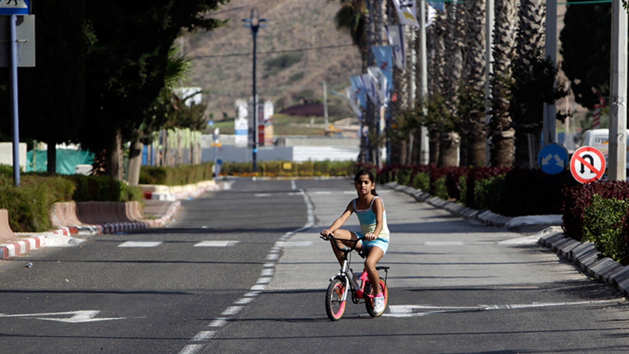 ISRAEL/ A girl rides her bike on an empty street during the Jewish holiday of Yom Kippur in the northern Israeli city of Acre October 8, 2011. Yom Kippur, or Day of Atonement, is the holiest of Jewish holidays, when observant Jews atone for the sins of the past year. REUTERS/Ammar Awad (ISRAEL - Tags: RELIGION SOCIETY) - RTR2SEJU