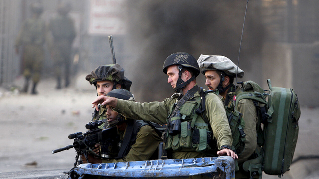 ISRAEL-PALESTINIANS/ Israeli soldiers take position during clashes with Palestinian protesters in the occupied West Bank city of Hebron October 4, 2015. Israeli Prime Minister Benjamin Netanyahu's office said he would meet security chiefs later on Sunday to discuss more action to tackle a rising wave of violence in East Jerusalem, which includes the Old City, and the West Bank, areas that Israel captured in a 1967 war. REUTERS/Mussa Qawasma - RTS2YR1