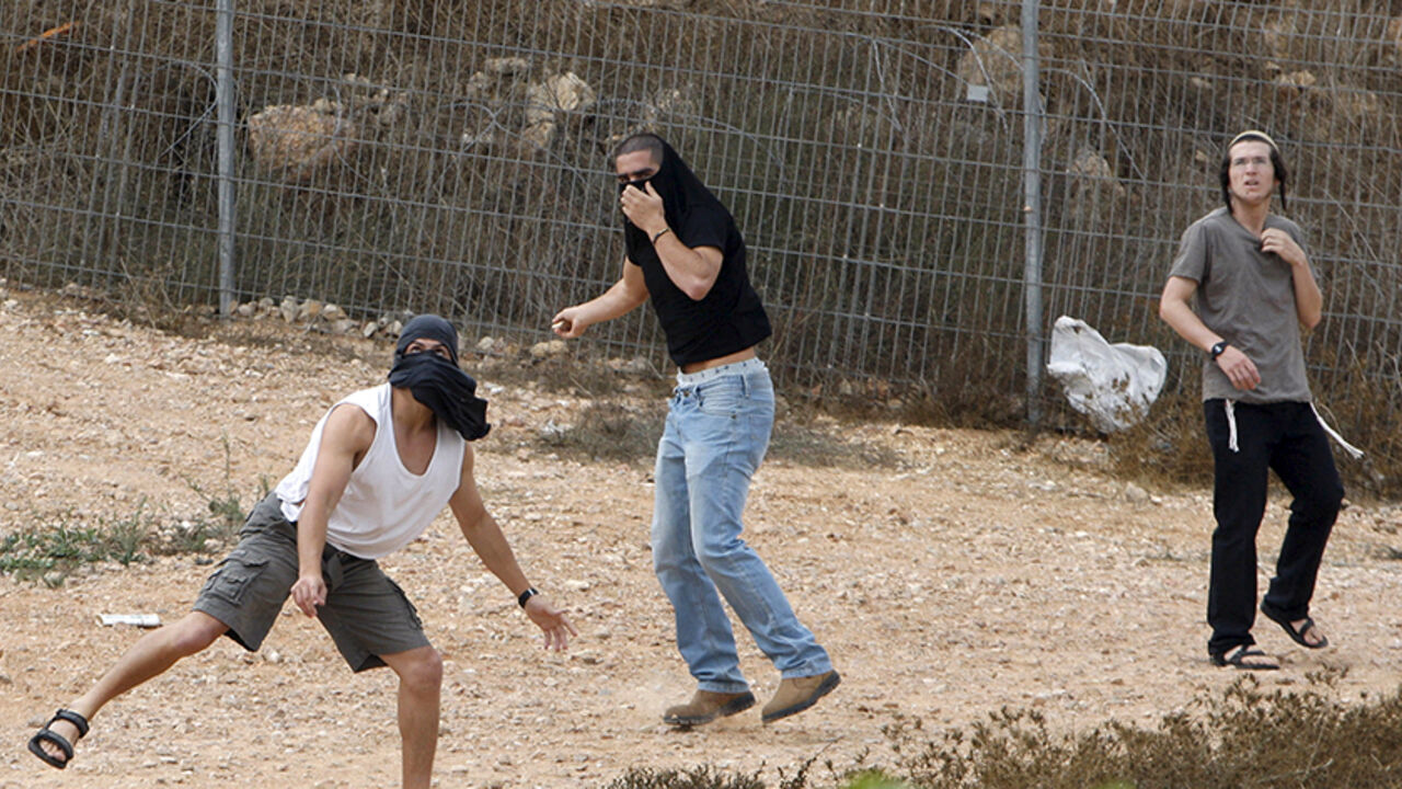 ISRAEL-PALESTINIANS/VIOLENCE Israeli settlers throw stones at Palestinian houses (not seen) in the West Bank city of Hebron October 9, 2015. Four Arabs were stabbed in a town in southern Israel on Friday and a Jewish suspect was arrested, police said. The attacks follow a surge in knife violence by Palestinians against Israelis. REUTERS/Mussa Qawasma - RTS3PRD