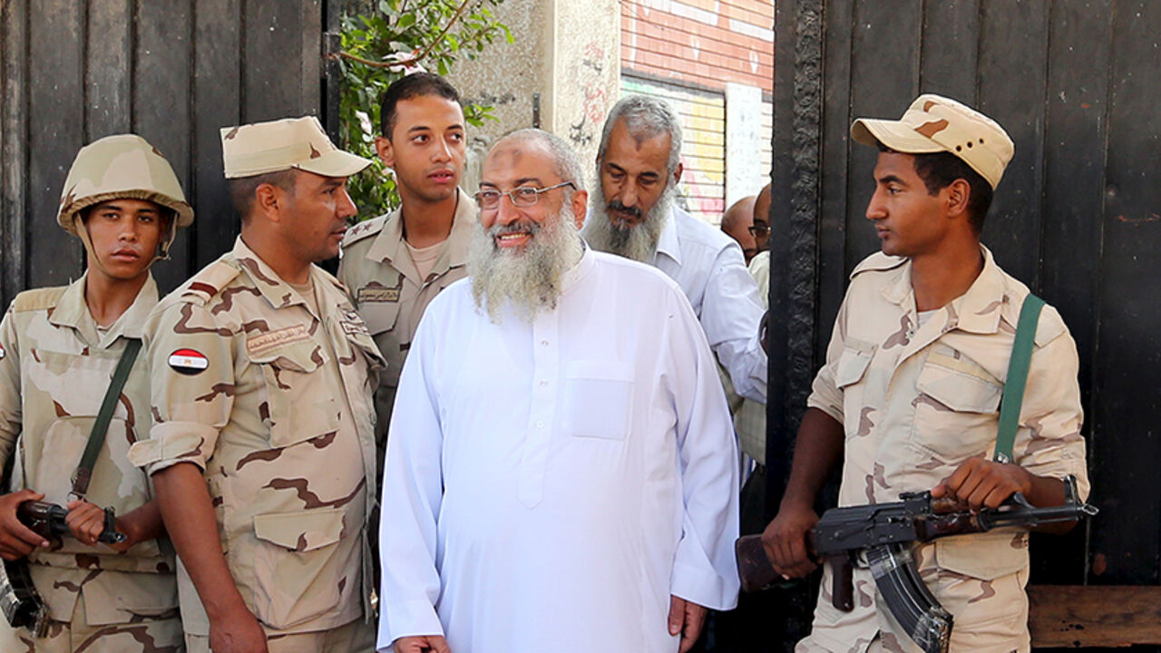EGYPT-ELECTIONS/ Security forces stand guard as Salafist cleric leader Yasser Borhamy leaves a school used as voting centr after he was casting his vote, in Alexandria, Egypt, October 18, 2015. Egypt kicked off a long-awaited parliamentary election on Sunday, the final step in a process that was meant to put the country back on a democratic course but which critics say has been undermined by state repression. REUTERS/Asmaa Waguih - RTS4YZI