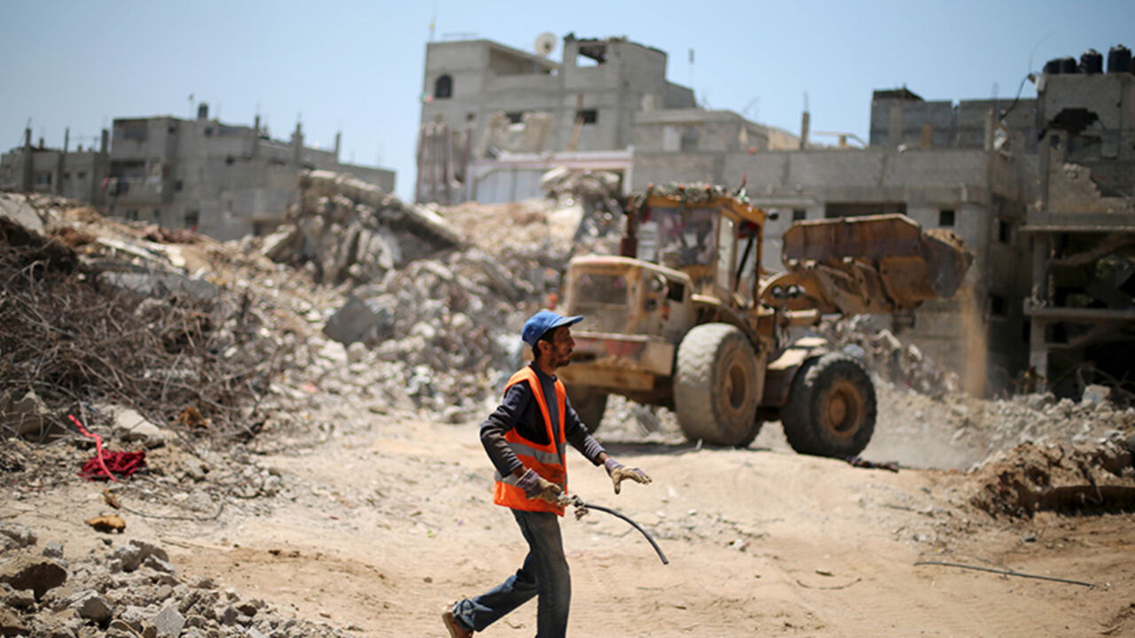PALESTINIANS-RECONCILIATION/ A Palestinian worker salvages metal as others clear the rubble of houses that witnesses said were destroyed by Israeli shelling during a 50-day war last summer, in the east of Gaza City May 6, 2015. In recent weeks, a flurry of envoys has beaten a path to Gaza's door: representatives from Qatar, Turkey, the United Nations, the European Union and former U.S. president Jimmy Carter have all visited or tried to visit. The impact of the stand-off is widespread, but in two areas it is particularly problematic: i