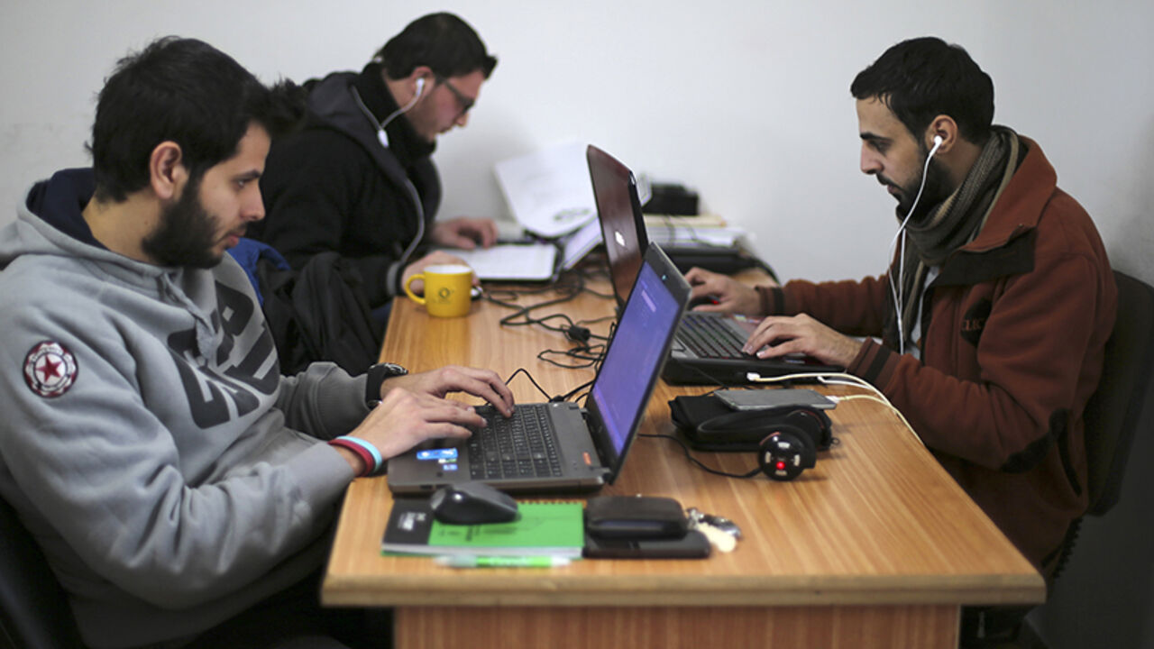 MIDEAST-PALESTINIANS/TECHNOLOGY Palestinian employees process data on their laptops at Unit One in Gaza City January 15, 2015. In nine years, Gaza-based IT entrepreneur Saady Lozon and his partner Ahmed Abu Shaban have transformed their firm, Unit One, from a tiny outfit in a single room in the blockaded Gaza Strip into a successful business with clients in Europe, the United States and the Arab world. They can't leave Gaza easily, but they can develop applications for Web and mobile devices online and provide international clients with d