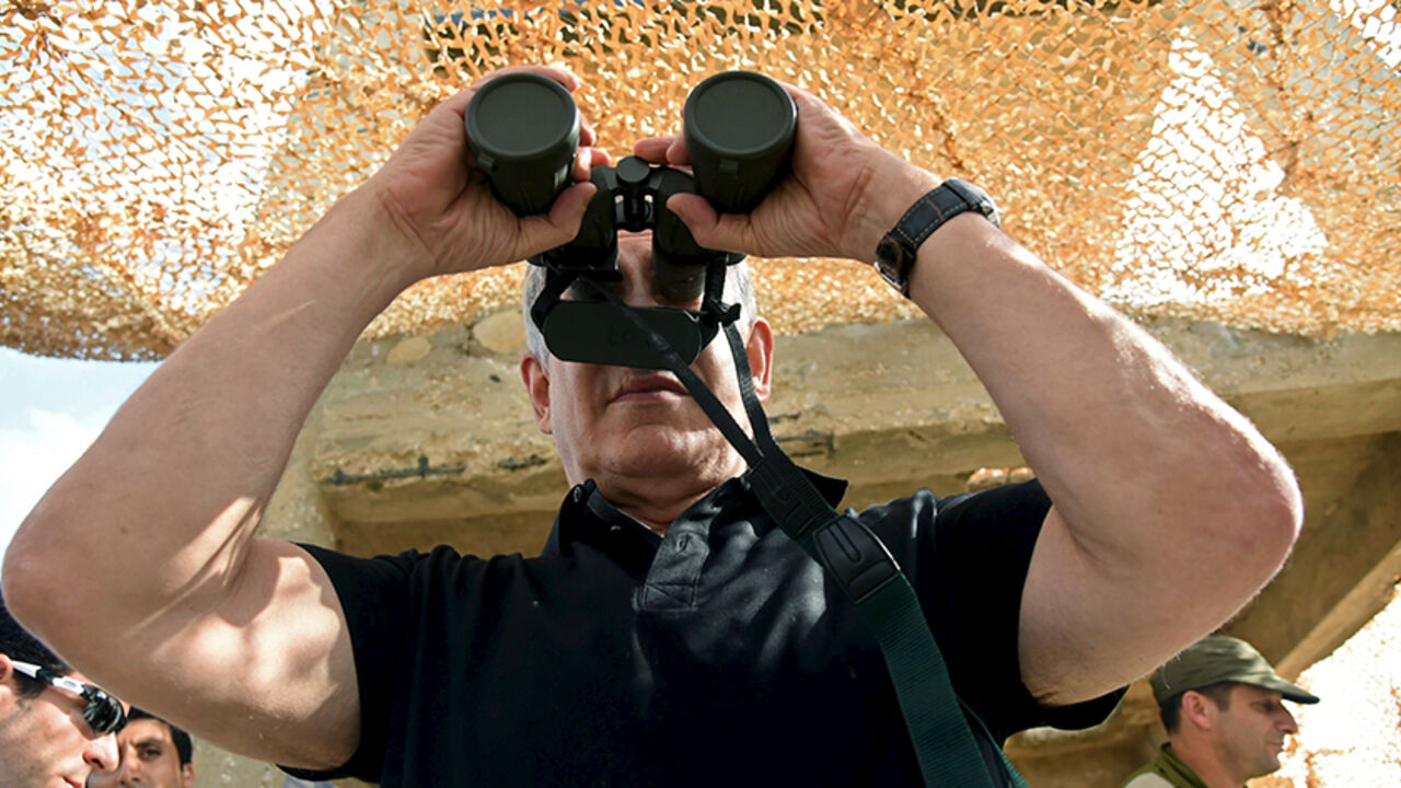 Israel's Prime Minister Benjamin Netanyahu looks into a pair of binoculars, which lenses are covered, as he visits a military outpost on the outskirts of Gaza Strip October 20, 2015.  REUTERS/Haim Horenstein/Pool - RTS5BAR