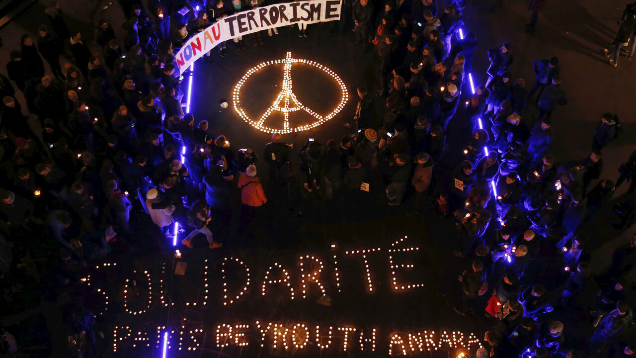 FRANCE-SHOOTING/SWISS People gather around candles during a ceremony for the victims the day after a series of deadly attacks in the French capital of Paris, in Lausanne, Switzerland November 14, 2015. The banner reads : "No to terrorism" and the candles reads : Solidarity Paris Beyrouth Ankara" REUTERS/Denis Balibouse TPX IMAGES OF THE DAY - RTS729Y
