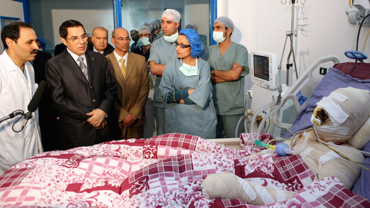 63048946 A handout picture released by the Tunisian Presidency shows Tunisian president Zine El-Abidine Ben Ali (2nd L) looking at Mohamed Al Bouazzizi (R), during his visit at the hopital in Ben Arous near Tunis on December 28, 2010. Mohamed Al Bouazzizi, a 26-year-old university graduate, who was forced to sell fruit and vegetables on the streets, doused himself in petrol and set himself alight on December 17, which left him in a serious condition with severe burns. Days of rioting in Tunisia by mostly jobless