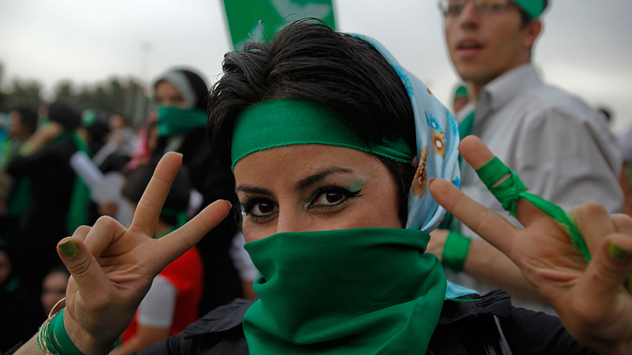 IRAN-ELECTION/ A supporter of Iran's former Prime Minister Mirhossein Mousavi, who is a candidate in the upcoming presidential elections, gestures during a rally in Tehran on the last day of campaigning June 10, 2009. Green is the campaign colour of Mousavi. REUTERS/Ahmed Jadallah (IRAN POLITICS ELECTIONS) - RTR24IVK