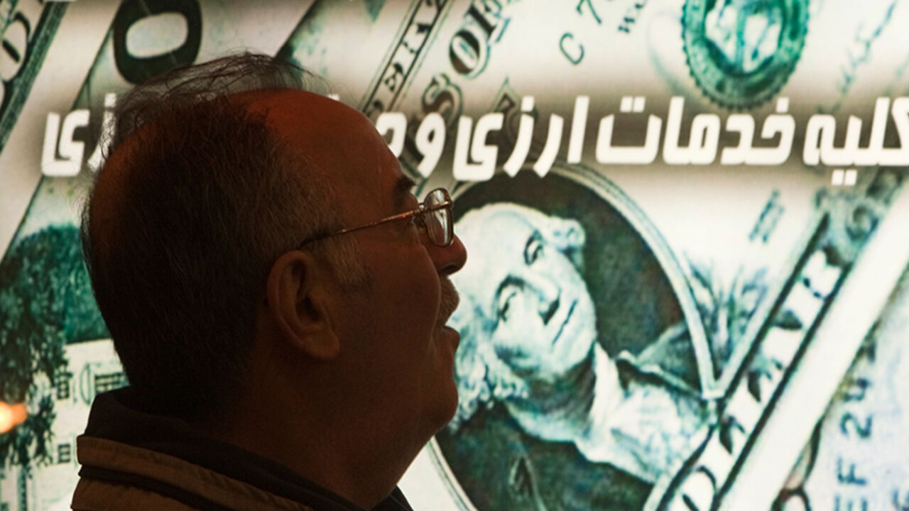 IRAN-CURRENCY/DOLLAR EDITORS' NOTE: Reuters and other foreign media are subject to Iranian restrictions on leaving the office to report, film or take pictures in Tehran.
An Iranian man walks past a currency exchange shop in northern Tehran January 3, 2012. The Iranian rial fell to a record low against the dollar on Tuesday following U.S. President Barack Obama signing a bill on imposing fresh sanctions against the country's central bank. REUTERS/Morteza Nikoubazl (IRAN - Tags: BUSINESS POLITICS) - RTR2VU6Z