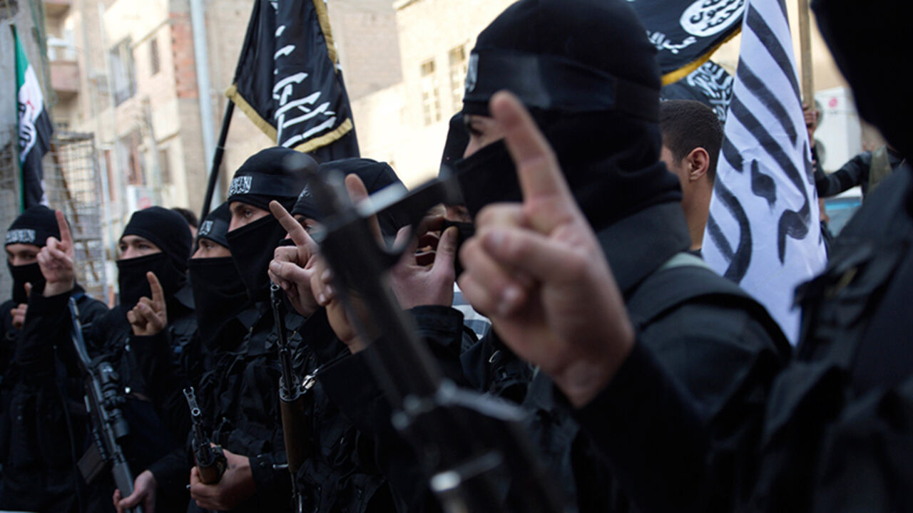SYRIA-CRISIS/ Members of an Islamist group hold their weapons during a protest against Syria's President Bashar al-Assad's regime in Deir el-Zor, February 25, 2013. Picture taken February 25, 2013. REUTERS/Khalil Ashawi (SYRIA - Tags: CONFLICT) - RTR3EAXZ
