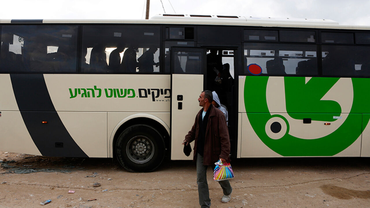 Labourers disembark a Palestinians-only bus before crossing through Israel's Eyal checkpoint as they returns to the West Bank, near Qalqilya March 4, 2013. Israel launched two Palestinians-only bus lines in the occupied West Bank on Monday, a step an Israeli rights group described as racist and which the Transport Ministry called an improvement in service. REUTERS/Baz Ratner (ISRAEL - Tags: POLITICS TRANSPORT) - RTR3EKIH