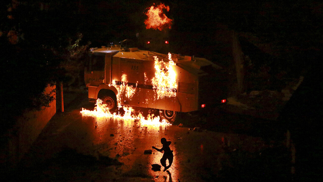 TURKEY-KURDS/ A man runs a way from a burning police vehicle during clashes between riot police and Kurdish militants in Van, eastern Turkey, August 27, 2015. Seven people, including at least four civilians, were killed on Thursday in clashes between Turkey's armed forces and militants in the mainly Kurdish southeast, security sources and the army said. A 2-1/2-year-old ceasefire between Turkey and Kurdish militants collapsed in July after a group close to Kurdistan Workers Party (PKK) rebels shot dead two police officer