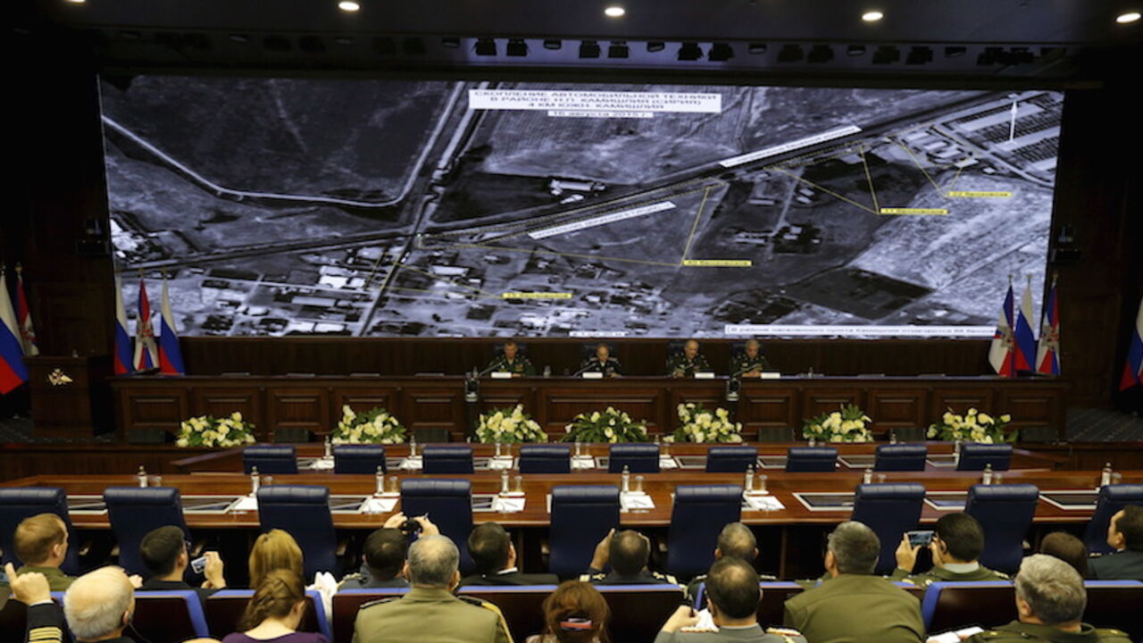 MIDEAST-CRISIS/RUSSIA-TURKEY Defence ministry officials sit under screens with satellite images on display during a briefing in Moscow, Russia, December 2, 2015. Russia's defence ministry said on Wednesday it had proof that Turkish President Tayyip Erdogan and his family were benefiting from the illegal smuggling of oil from Islamic State-held territory in Syria and Iraq. REUTERS/Sergei Karpukhin - RTX1WTWJ