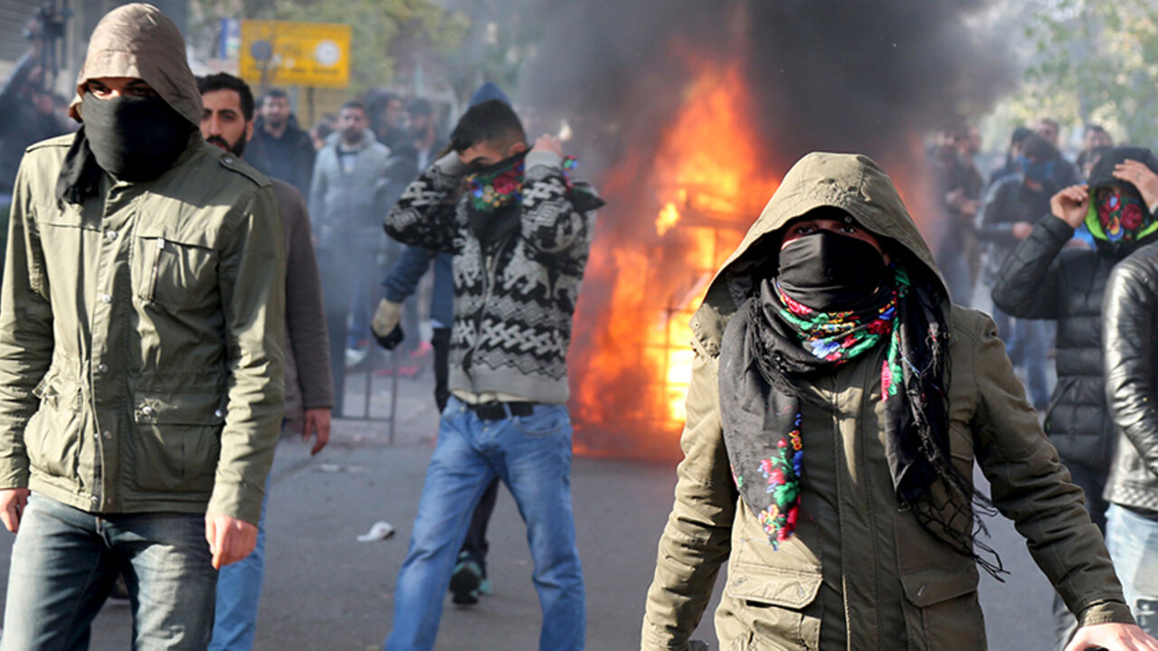 TURKEY-KURDS/ Demonstrators cover their faces as they clash with riot police during a protest against the curfew in Sur district, in the southeastern city of Diyarbakir, Turkey, December 14, 2015. Turkish police fired tear gas and water cannon to disperse a protest against a security crackdown in the main southeastern city of Diyarbakir on Monday, witnesses said, while curfews were declared elsewhere in the region. Turkey's mainly Kurdish southeast has been beset by unrest in recent months as security forces battle Kurdi