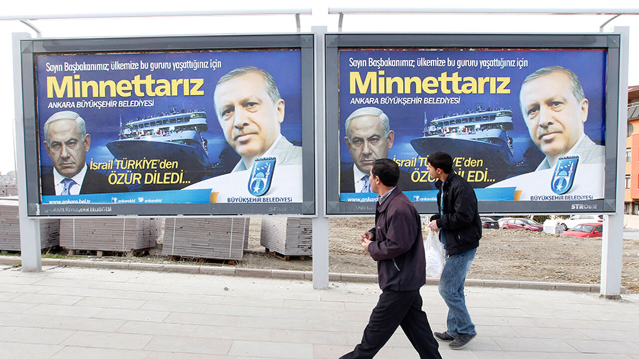 TURKEY-ISRAEL/ERDOGAN Pedestrians look at billboards with the pictures of Turkey's Prime Minister Tayyip Erdogan (R) and his Israeli counterpart Benjamin Netanyahu (L), in Ankara March 25, 2013. Turkey's Prime Minister Tayyip Erdogan said on Saturday an Israeli apology for the 2010 deaths of nine Turkish pro-Palestinian activists that was brokered by U.S. President Barack Obama met Turkey's conditions and signalled its growing regional clout. The billboard reads, "Israel apologized to Turkey. Dear Prime Minister (Erdogan), We ar