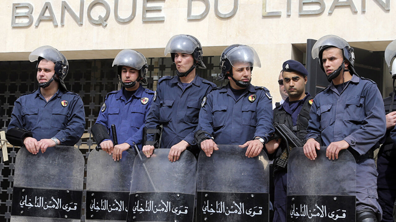 LEBANON/ Lebanese riot police stand guard at the Lebanese Central Bank in Beirut February 25, 2013. An open-ended strike by teachers and civil servants entered its second week today for the government to approve the wage hike proposal. REUTERS/Mohamed Azakir (LEBANON - Tags: POLITICS CIVIL UNREST) - RTR3E9U4