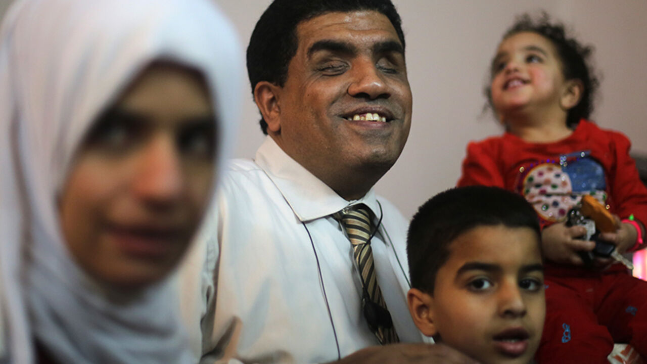 EGYPT/ Blind lawyer Khaled Hanafy smiles next to his wife Sherien Fathy, who is also blind, near their son Yehia and daughter Rahma at their home in Cairo March 5, 2014. Sherien, 32, a graduate of the College of Arts? Arabic department who works as a specialist manager at the General Petroleum Corporation, hopes the government will do more to help disabled people to find jobs and contribute to the economy. On March 8 activists around the globe celebrate International Women's Day, which dates back to the beginning
