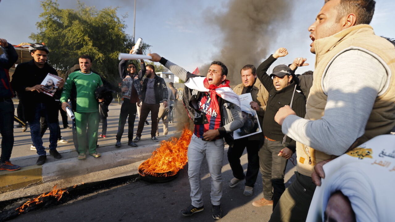 SAUDI-IRAN/IRAQ Supporters of Shi'ite cleric Moqtada al-Sadr shout as they stand near a burning tyre during a demonstration against the execution of Shi'ite Muslim cleric Nimr al-Nimr in Saudi Arabia, in Baghdad, Iraq January 4, 2016. REUTERS/Thaier Al-Sudani - RTX20ZMU