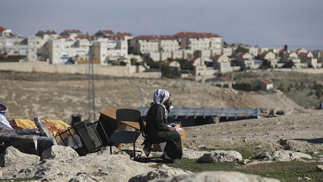 ISRAEL-PALESTINIANS/ A Palestinian man smokes a cigarette as he sits near his belongings after the Israeli army demolished his shanty, that his family lives in, near the Israeli West Bank settlement of Maale Adumim, near Jerusalem January 6, 2016. The owners of the shanty said they were informed by the Israeli army that the demolition was carried out because they did not have Israeli-issued permits to reside in the area. REUTERS/Mohamad Torokman - RTX2199M