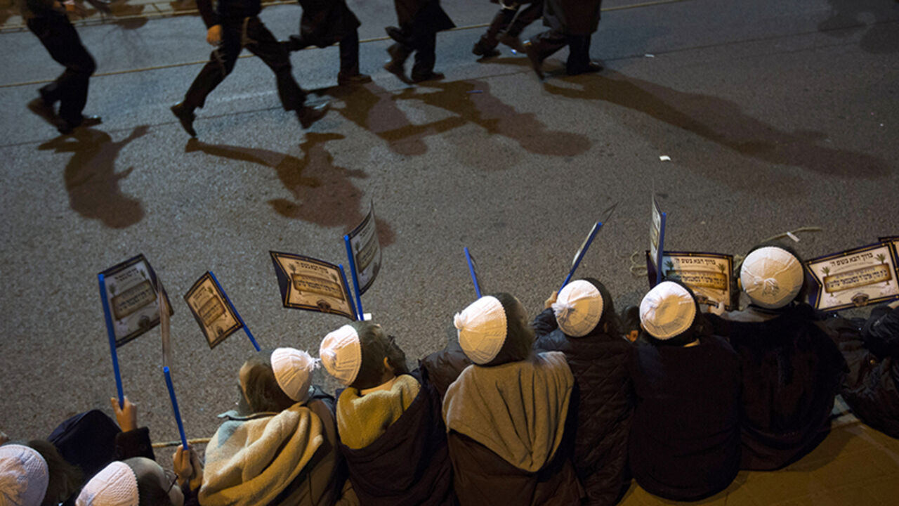 ISRAEL/ Ultra-Orthodox Jewish boys hold flags during a rally organised to welcome Rabbi Zalman Leib Teitelbaum, in Jerusalem's Mea Shearim neighbourhood January 20, 2013. Local media said that Rabbi Zalman Leib Teitelbaum, son of the late Rabbi Moses Teitelbaum, leader of the Satmar Hasidim landed in Israel on Sunday for the wedding of his granddaughter which will take place later in the week. REUTERS/Ronen Zvulun (JERUSALEM - Tags: RELIGION) - RTR3CPHG