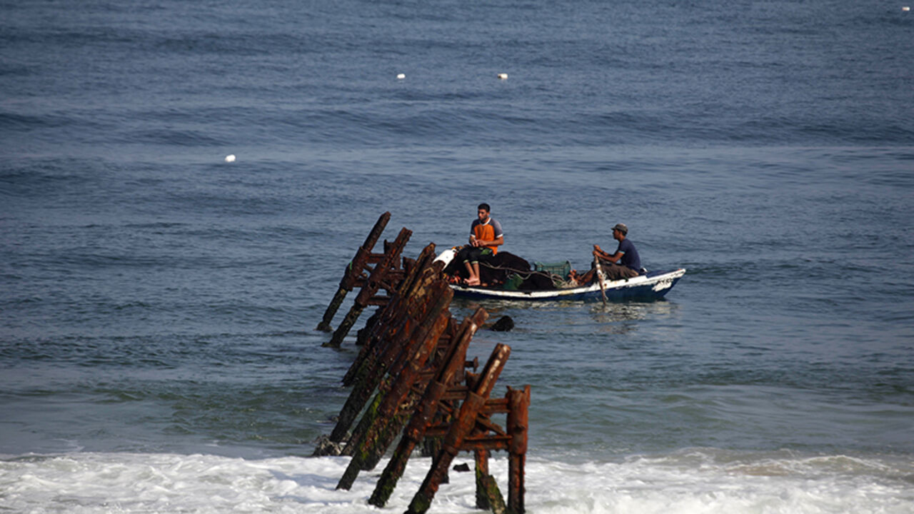 PALESTINIANS/ Palestinian fishermen ride a boat as they fish in the Mediterranean Sea off the coast of Rafah in the southern Gaza Strip, near Egypt's territorial water September 15, 2013. REUTERS/Ibraheem Abu Mustafa (GAZA - Tags: SOCIETY) - RTX13LWD