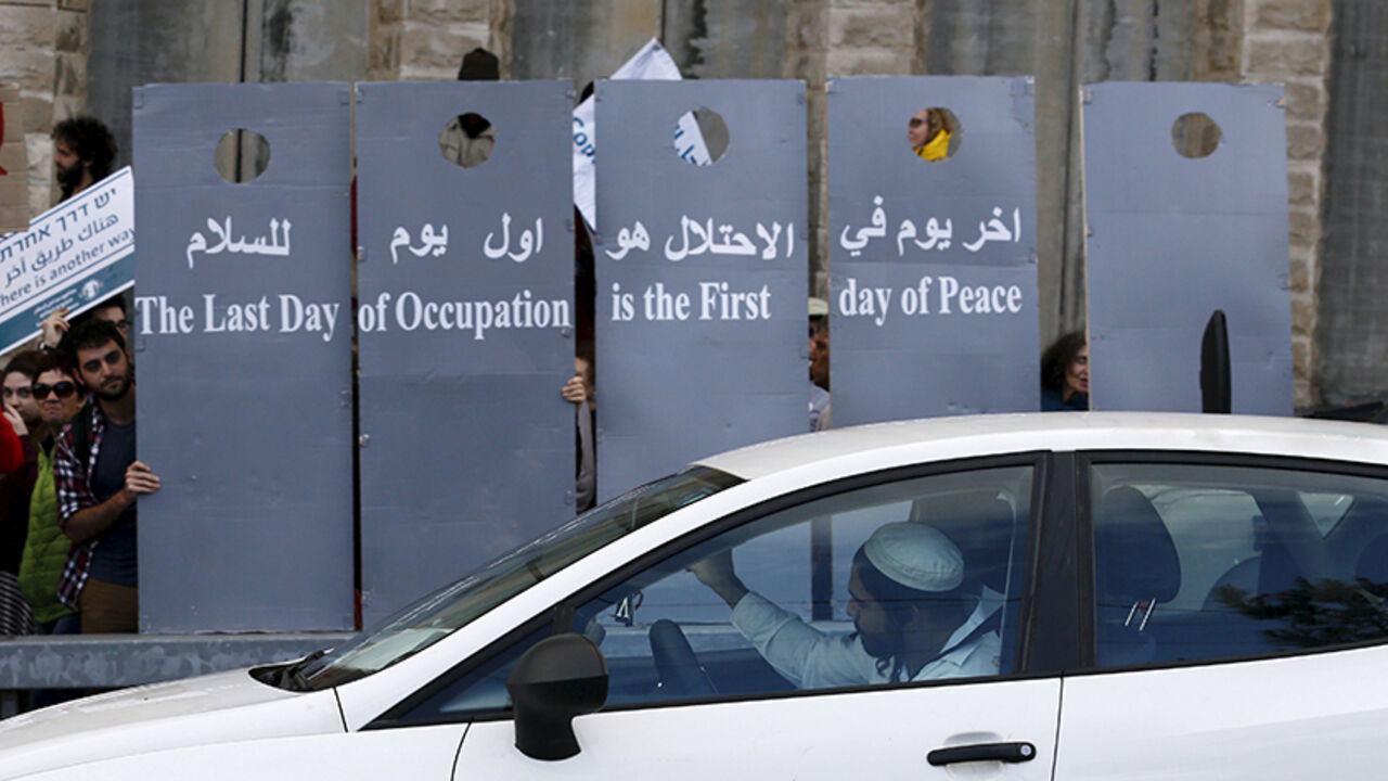 ISRAEL-PALESTINIANS/ Left-wing Israelis and Palestinians demonstrators hold placards during a demonstration calling for a better future for both people, at the West Bank near Jerusalem January 15, 2016. REUTERS/Amir Cohen - RTX22JI8