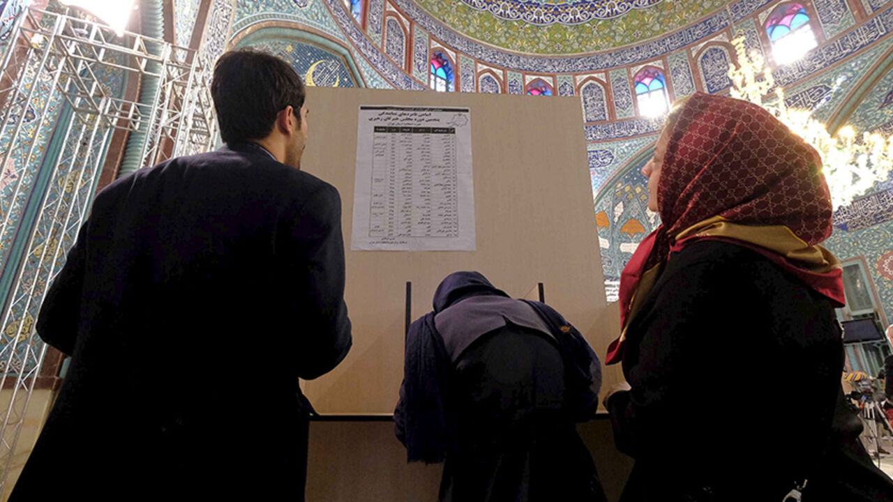 IRAN-ELECTION/ Iranians look at a list of candidates' names during elections for the parliament and Assembly of Experts, which has the power to appoint and dismiss the supreme leader, at a polling station in Tehran February 26, 2016. REUTERS/Raheb Homavandi/TIMA ATTENTION EDITORS - THIS IMAGE WAS PROVIDED BY A THIRD PARTY. FOR EDITORIAL USE ONLY. - RTX28NK7