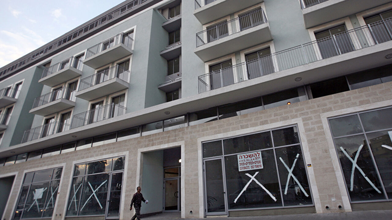 ISRAEL-ARABS/PROPERTY A man walks near a "for rent" sign posted on a newly-built residential building in Jaffa, just south of central Tel Aviv, January 4, 2010. Almost 500 Arab families are struggling to keep a toehold in Ajami, the Arab section of Jaffa that is rapidly becoming an artsy alternative to the brash modernity of Israel's metropolis Tel Aviv next door. Picture taken January 4, 2010. To match feature ISRAEL-ARABS/PROPERTY REUTERS/Gil Cohen Magen (ISRAEL - Tags: POLITICS BUSINESS SOCIETY) - RTR28TF5