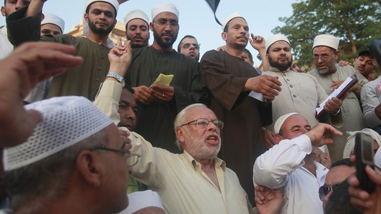 EGYPT/ Christian activist George Isaac (C) chants with religious Muslim scholars from Al-Azhar school as they gather with other protesters to demonstrate against presidential candidate Ahmed Shafiq at Tahrir square in Cairo June 5, 2012. REUTERS/Asmaa Waguih (EGYPT - Tags: POLITICS CIVIL UNREST ELECTIONS) - RTR335FQ