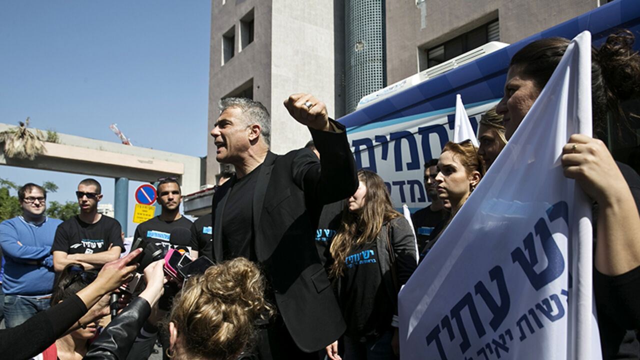 ISRAEL-ELECTION/ Yesh Atid leader Yair Lapid (C) speaks to members of the media in Tel Aviv before heading on a campaign tour March 15, 2015. Once a heartthrob television news anchor, Lapid, 51, was the rising star of Israeli politics in the 2013 election. His centrist Yesh Atid party came second behind Netanyahu's Likud. REUTERS/Baz Ratner (ISRAEL - Tags: POLITICS ELECTIONS) - RTR4TEHU