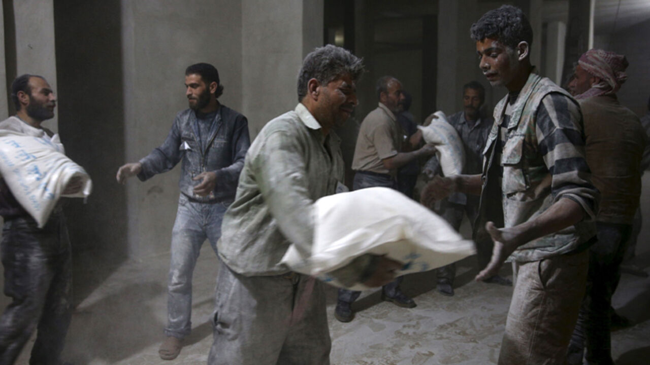 Men store bags of flour unloaded from a Red Crescent aid convoy in the rebel held besieged town of Jesreen, in the eastern Damascus suburb of Ghouta, Syria March 7, 2016. REUTERS/Bassam Khabieh      TPX IMAGES OF THE DAY      - RTS9Q41
