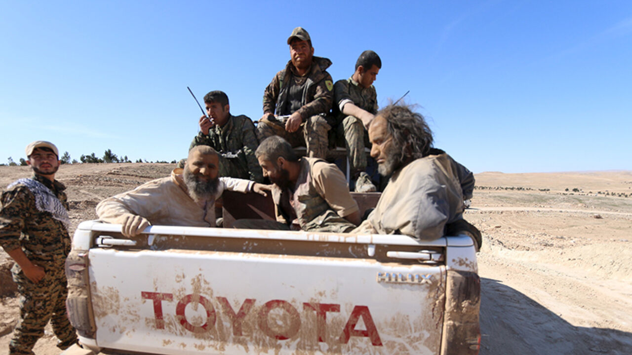 MIDEAST-CRISIS/HASAKA-ISLAMIC-STATE Three men that Democratic Forces of Syria fighters claimed were Islamic State fighters sit on a pick-up truck while being held as prisoners, near al-Shadadi town, Hasaka countryside, Syria, February 18, 2016. REUTERS/Rodi Said - RTX27LV4
