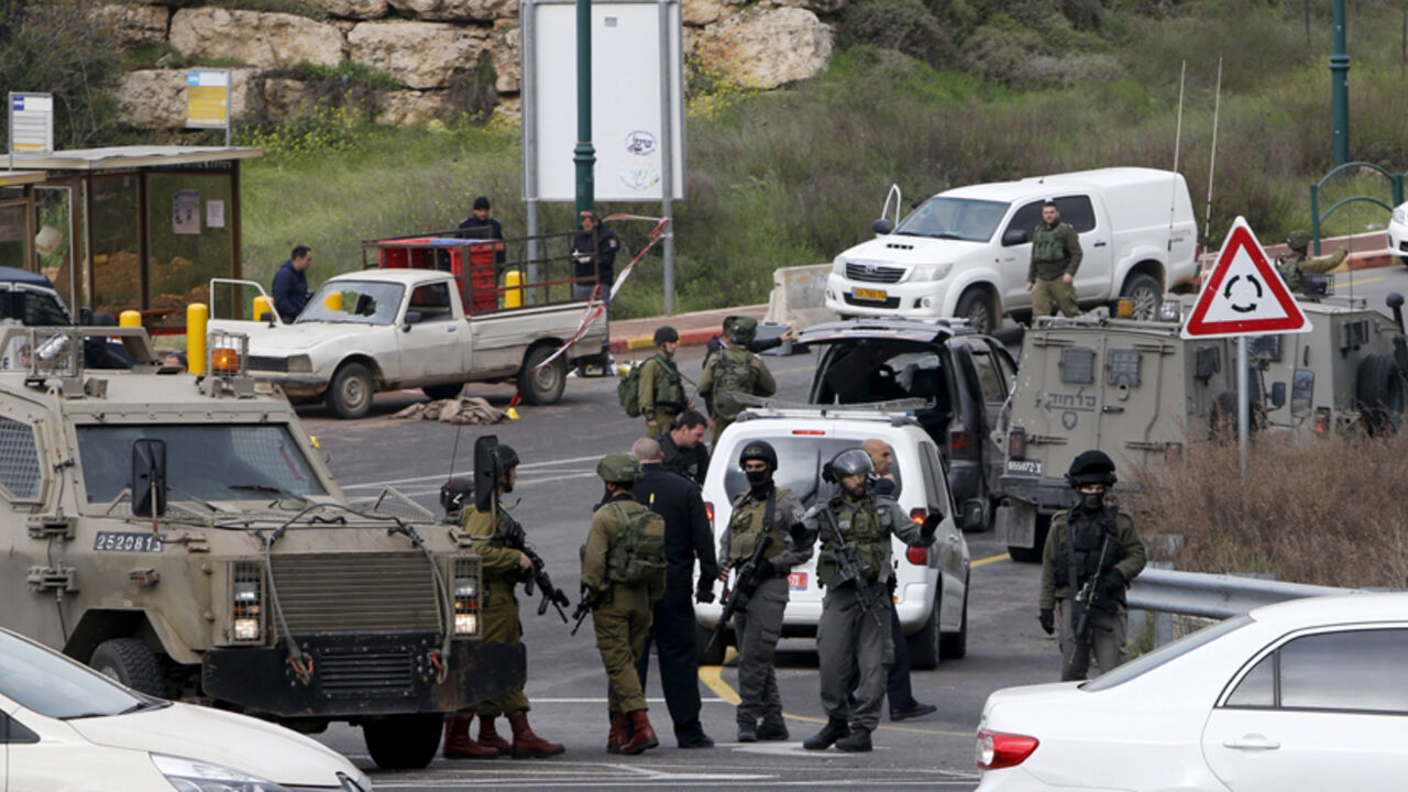 ISRAEL-PALESTINIANS/VIOLENCE Israeli security forces gather near the scene of what the Israeli military said were back-to-back gun and car-ramming attacks by Palestinians, near the Jewish settlement of Kiryat Arba near the West Bank city of Hebron March 14, 2016. Three Palestinians carried out back-to-back gun and car-ramming attacks on Israelis near a Jewish settlement in the occupied West Bank on Monday and were shot dead by the army, it said. REUTERS/Mussa Qawasma - RTX290TP