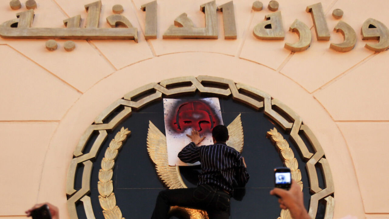 EGYPT/PROTEST A protester spray paints a picture of the late activist Khaled Said on the emblem of the Ministry of Interior building during a demonstration against police brutality in Cairo, on the first anniversary of Said's death, June 6, 2011. Said, 28, was beaten to death by police in Alexandria in June 2010 with his body barely recognisable after he posted a video showing police officers sharing the spoils of a drugs bust, according to his family. The act of brutality galvanised further protests, in particular, the