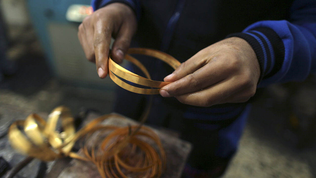 PALESTINIANS-DAILYLIFE/ A Palestinian worker holds gold bracelets at a jewellery workshop in Gaza City March 3, 2015. REUTERS/Mohammed Salem (GAZA - Tags: BUSINESS EMPLOYMENT SOCIETY) - RTR4RUQM