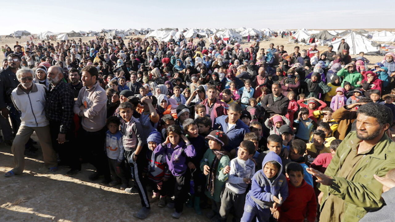 MIDEAST-CRISIS/JORDAN-SYRIA REFUGEES Syrian refugees stuck between the Jordanian and Syrian borders, wait to cross into Jordan after a group of them crossed into Jordanian territory, near the town of Ruwaished, at the Hadalat area, east of the capital Amman, January 14, 2016. After months of being stranded at the border, a group of Syrian refugees has finally been allowed to enter Jordan. Jordanian authorities say they have to address security concerns before allowing more refugees into the country burdened with over 1.4 million refugees, sai