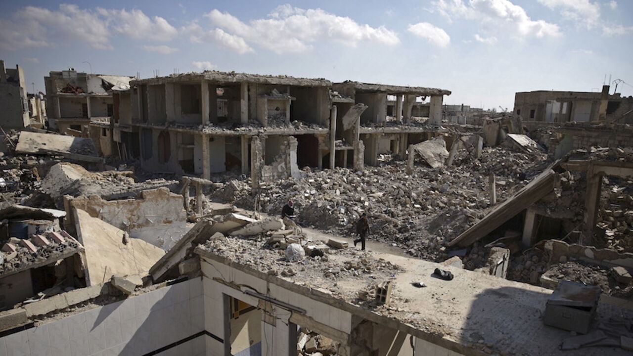 MIDEAST-CRISIS/SYRIA People walk past damaged buildings in the Douma neighbourhood of Damascus, Syria February 9, 2016. REUTERS/Bassam Khabieh TPX IMAGES OF THE DAY - RTX267OK