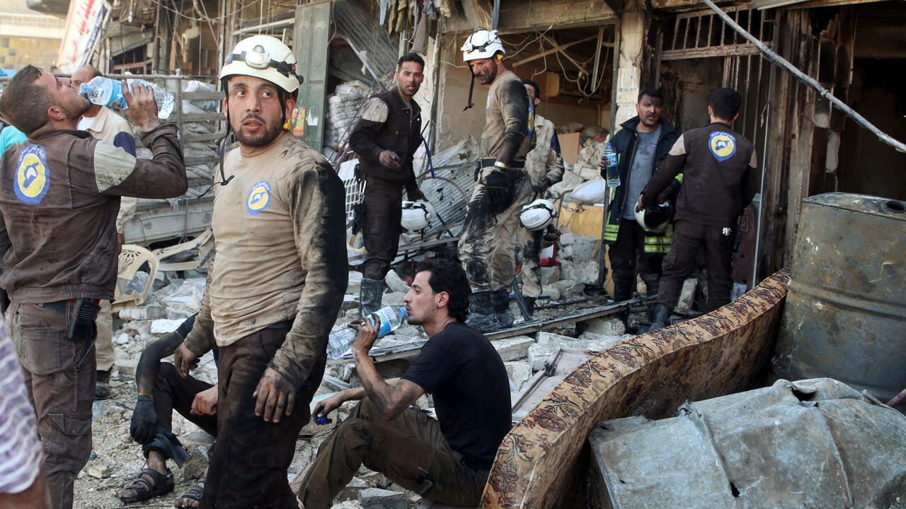 MIDEAST-CRISIS/SYRIA Civil defence members rest amid rubble of damaged buildings after an airstrike on the rebel-held Tariq al-Bab neighbourhood of Aleppo, Syria April 23, 2016. REUTERS/Abdalrhman Ismail TPX IMAGES OF THE DAY - RTX2BBAO