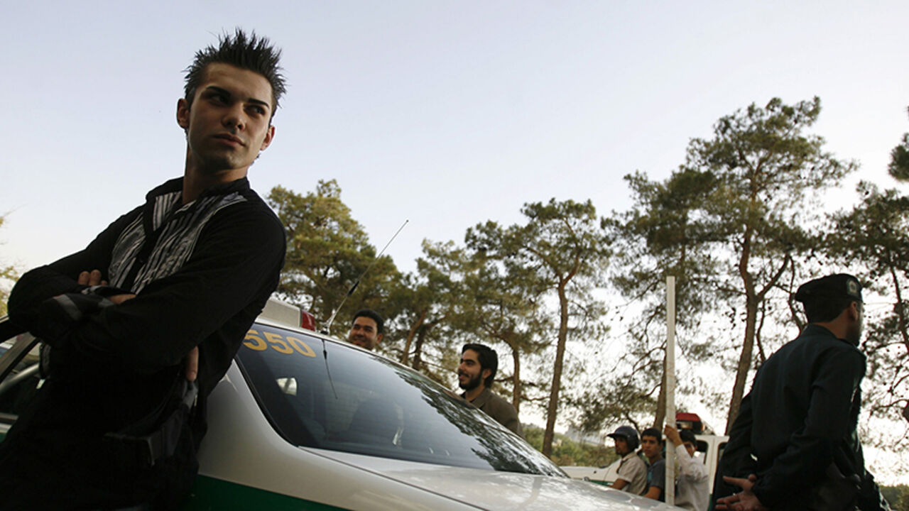 IRAN-CRACKDOWN/MORAL A youth leans against a police car after being detained for a Western-style haircut in Tehran June 16, 2008. Iranian police have launched a more extensive crackdown on "social corruption" such as women flouting Islamic dress codes, the Farhang-e Ashti newspaper reported on Monday. The daily also reported that men with Western-style haircuts were confronted by the police and barber shops that gave them such haircuts were sealed off. Picture taken June 16, 2008. REUTERS/Stringer (IRAN) - RTX71DO