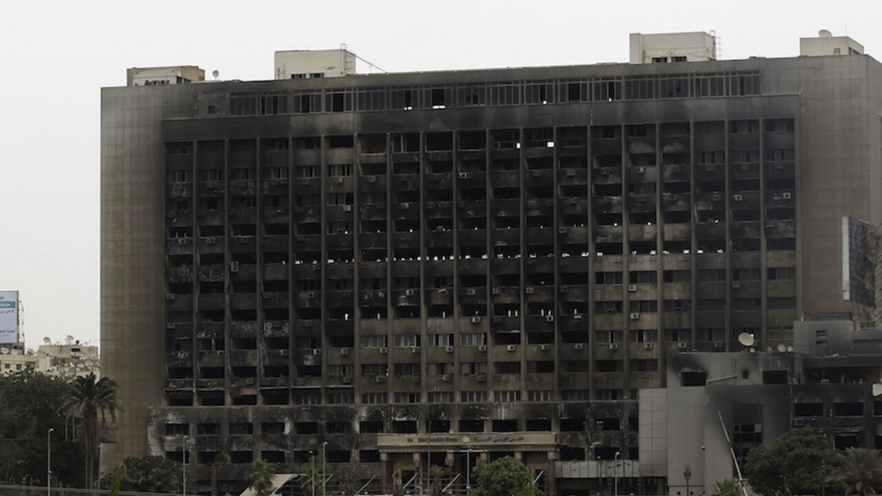 EGYPT-ELECTION/BROTHERHOOD The burned headquarters of former President Hosni Mubarak's National Democratic Party (NDP) is seen between campaign election billboards of presidential candidates, former Prime Minister Ahmed Shafiq (L), and Mohamed Mursi, the head of the Muslim Brotherhood's political party, in downtown Cairo May 28, 2012. The Brotherhood did what it does better than any other group in Egypt: mobilised a nationwide network to get out the vote, catapulting Mursi into the second round on June 16 and 17 against Shafiq, Hosni
