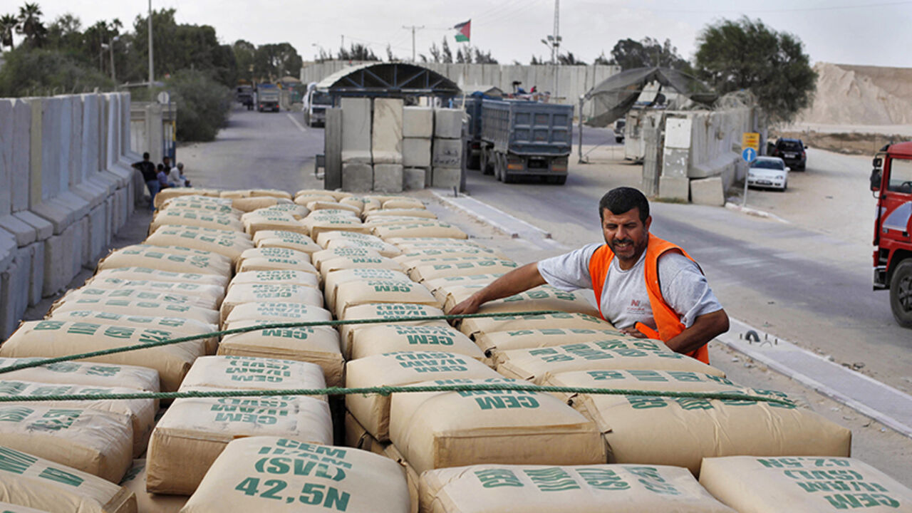 PALESTINIANS-ISRAEL/GAZA A Palestinian worker checks a truck loaded with cement bags after entering the Gaza Strip through the Kerem Shalom crossing September 22, 2013. Israel began allowing construction material for private projects into the Gaza Strip on Sunday for the first time in six years, in response to a request from Palestinian President Mahmoud Abbas, an Israeli defence official said. REUTERS/Ibraheem Abu Mustafa (GAZA - Tags: POLITICS BUSINESS CONSTRUCTION REAL ESTATE) - RTX13UHI