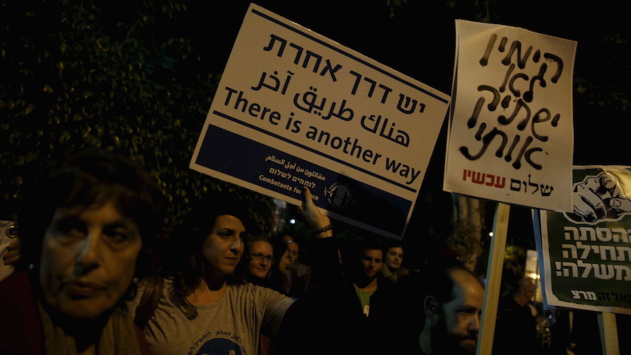 ISRAEL-NGOS-VIDEO Israeli left wing demonstrators march holding placards protesting the right wing incitement against President Reuven Rivlin and human rights activists in Tel Aviv. December 19, 2015. An ultra-nationalist Israeli group has published a video accusing the heads of four of Israel's leading human rights organisations of being foreign agents funded by Europe and supporting Palestinians "involved in terrorism". The sign (C) reads, "The right will not silence me." REUTERS/Baz Ratner - RTX1ZETU