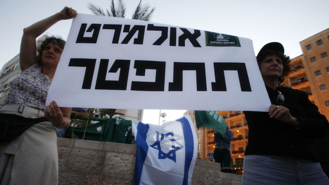 ISRAEL-OLMERT/ Israelis hold up a placard that reads in Hebrew "Olmert resign" during a protest near the official residence of Prime Minister Ehud Olmert in Jerusalem May 28, 2008. Olmert's main coalition partner demanded on Wednesday the Israeli prime minister leave office over corruption allegations. REUTERS/Baz Ratner (JERUSALEM) - RTX69FX