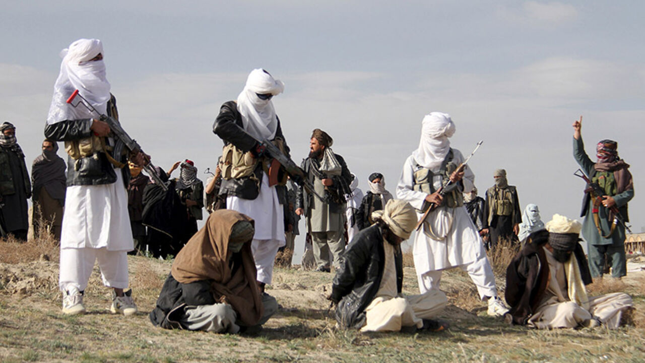 AFGHANISTAN-BLAST/ Taliban insurgents stand over three men, accused of murdering a couple during a robbery, before shooting them during their execution in Ghazni Province April 18, 2015. The Taliban announced the execution of the three men accused of murdering a couple during a robbery, saying they had been tried by an Islamic court. The killing was carried out in front of a crowd by Taliban fighters who fired at the men with AK-47s, according to a Reuters witness. Footage seen by Reuters show the men were made to sit on the