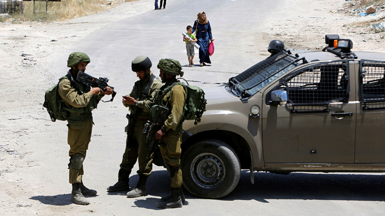 Israeli soldiers stand guard at the entrance of Yatta near the West Bank city of Hebron June 9, 2016. REUTERS/Mussa Qawasma       TPX IMAGES OF THE DAY      - RTSGPGK